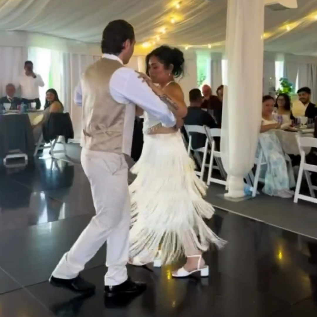 Wedding couple dancing while guests enjoy the reception during live portrait painting